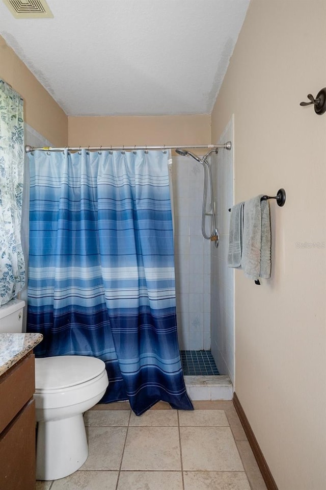 bathroom with curtained shower, tile patterned flooring, vanity, and toilet