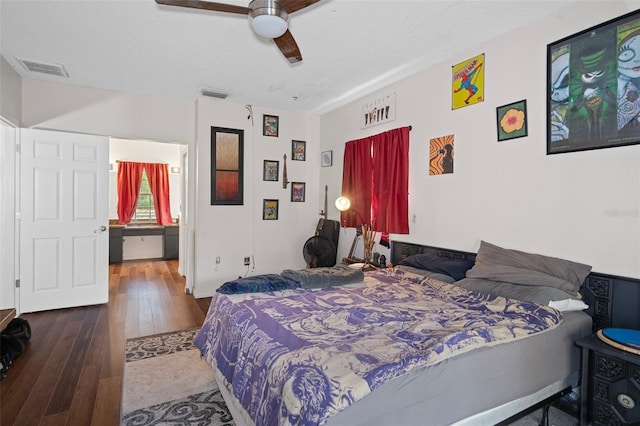 bedroom with hardwood / wood-style floors, ceiling fan, and a textured ceiling