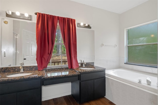 bathroom featuring hardwood / wood-style flooring, vanity, and separate shower and tub