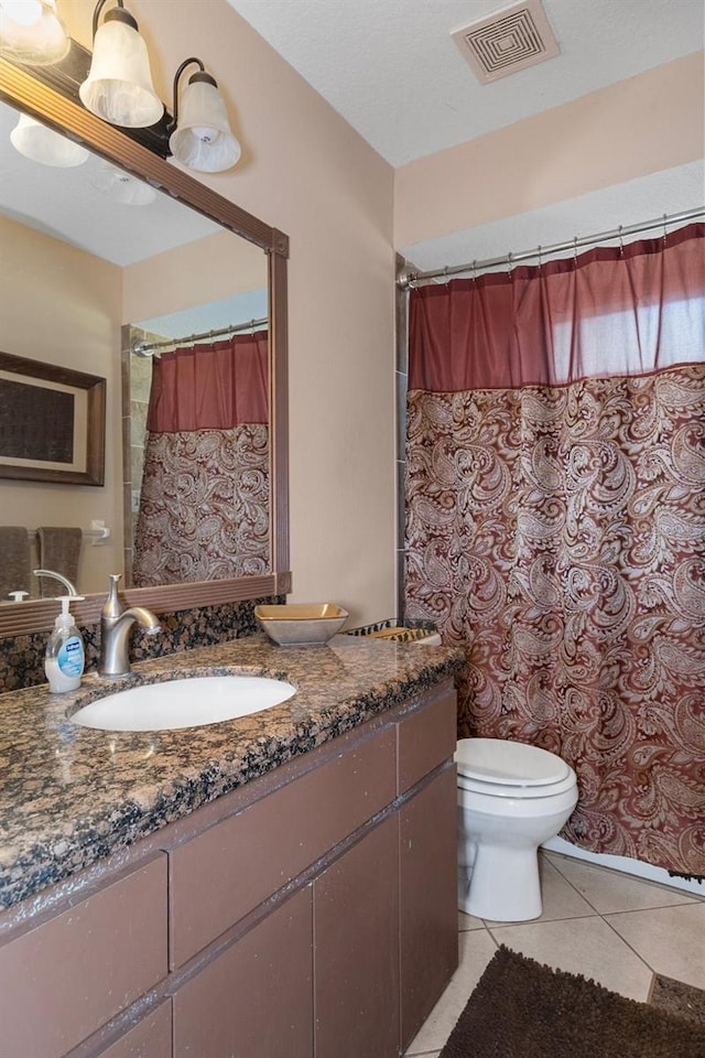 bathroom featuring tile patterned flooring, vanity, and toilet