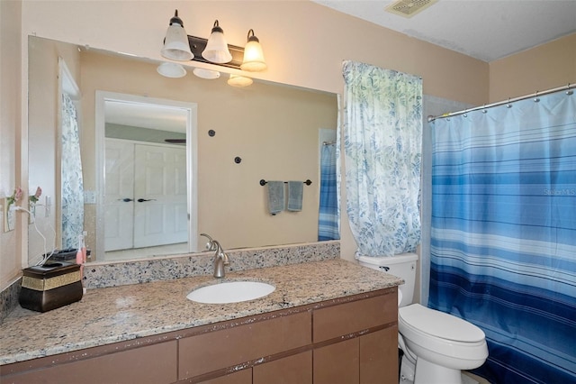 bathroom with walk in shower, vanity, and toilet