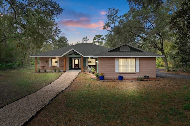 ranch-style home featuring brick siding, a porch, and a front lawn