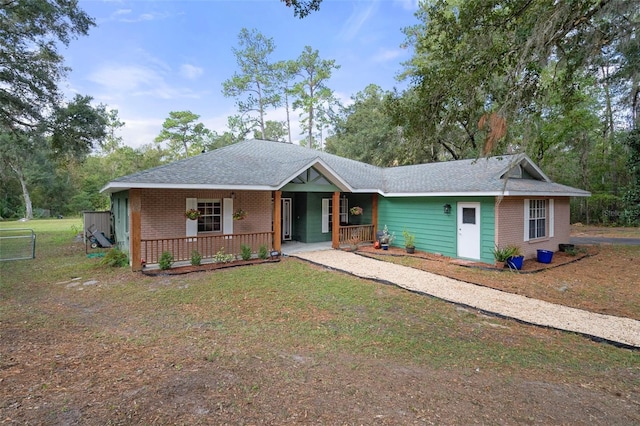ranch-style house featuring a front yard, a porch, and brick siding
