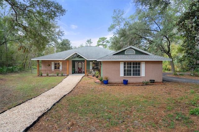 single story home featuring a front yard, a porch, and brick siding