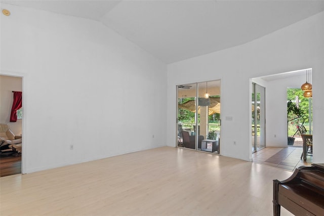 living area with vaulted ceiling and wood finished floors