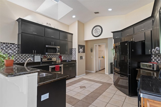 kitchen with visible vents, a skylight, a peninsula, appliances with stainless steel finishes, and dark cabinets