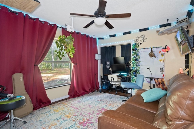 living area with a textured ceiling and a ceiling fan