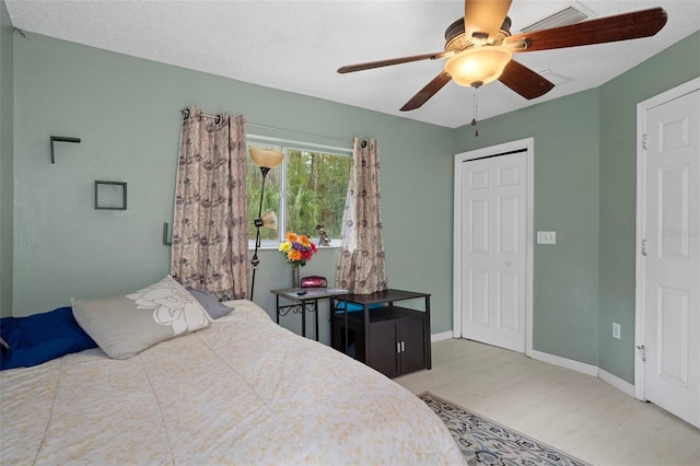 bedroom featuring light wood finished floors, baseboards, and ceiling fan