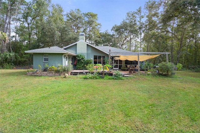 back of house featuring a lawn, a chimney, and a patio