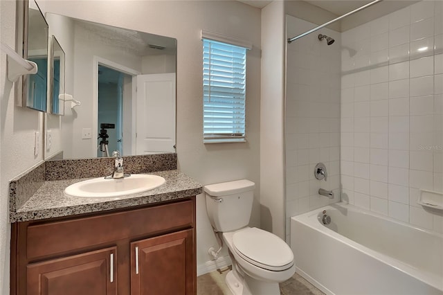 full bathroom with vanity, tiled shower / bath combo, and toilet