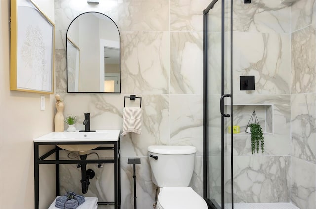 bathroom with a shower with door, toilet, and tile walls