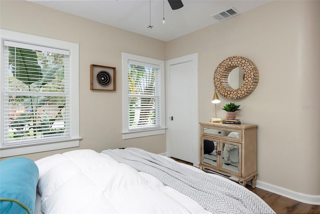 bedroom with multiple windows, dark hardwood / wood-style floors, and ceiling fan