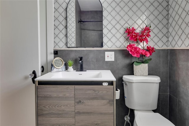 bathroom featuring tile walls, vanity, and toilet