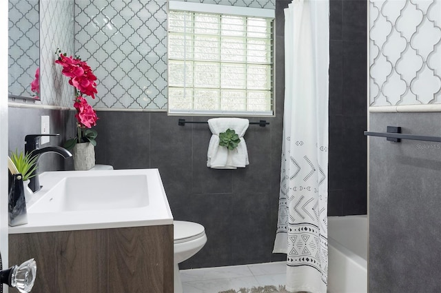 full bathroom with vanity, toilet, shower / bathtub combination with curtain, and tile walls