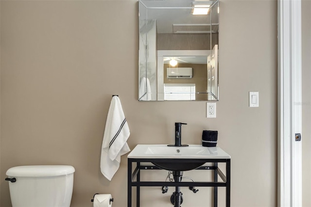 bathroom with toilet and a wall mounted air conditioner