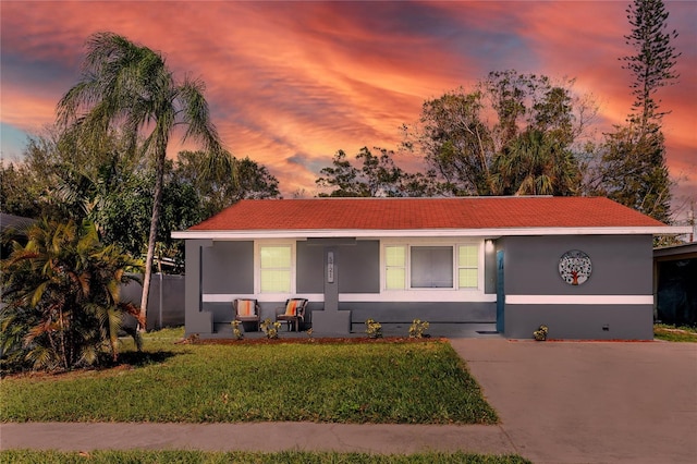 ranch-style home with a yard and a porch