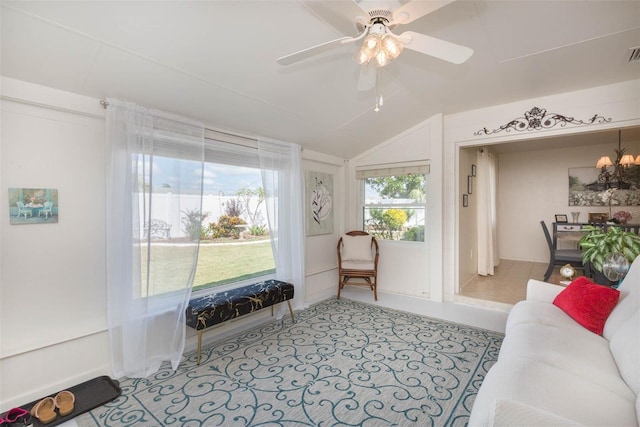 sitting room featuring vaulted ceiling and ceiling fan with notable chandelier