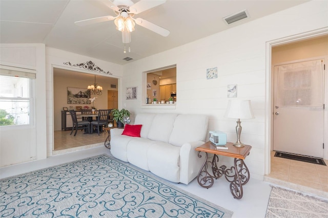 living room featuring lofted ceiling and ceiling fan with notable chandelier