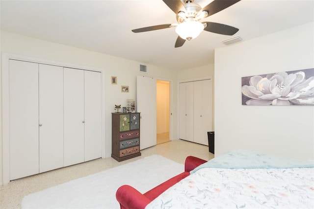 bedroom featuring ceiling fan and multiple closets