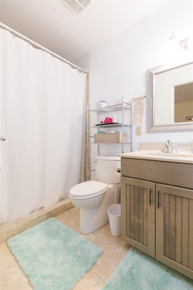 bathroom featuring toilet, vanity, and tile patterned flooring