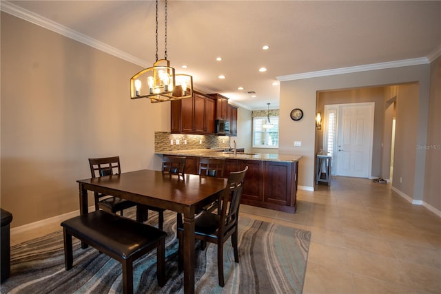 tiled dining space featuring ornamental molding and a chandelier