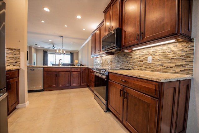 kitchen featuring appliances with stainless steel finishes, kitchen peninsula, decorative backsplash, light stone counters, and ornamental molding