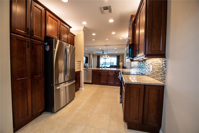 kitchen featuring kitchen peninsula, stainless steel appliances, pendant lighting, light stone counters, and tasteful backsplash