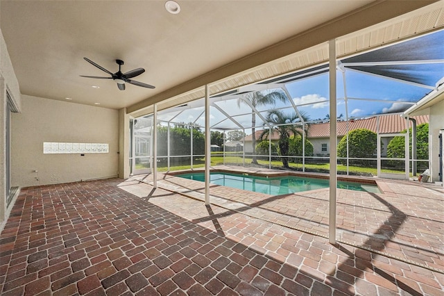 view of pool featuring a patio area, ceiling fan, and a lanai