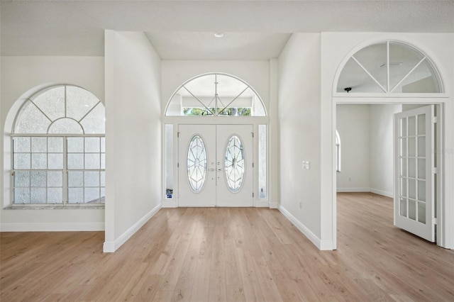 foyer entrance with light hardwood / wood-style floors and french doors