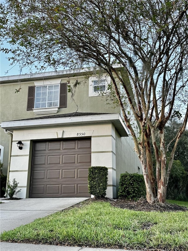 exterior space featuring driveway, an attached garage, and stucco siding