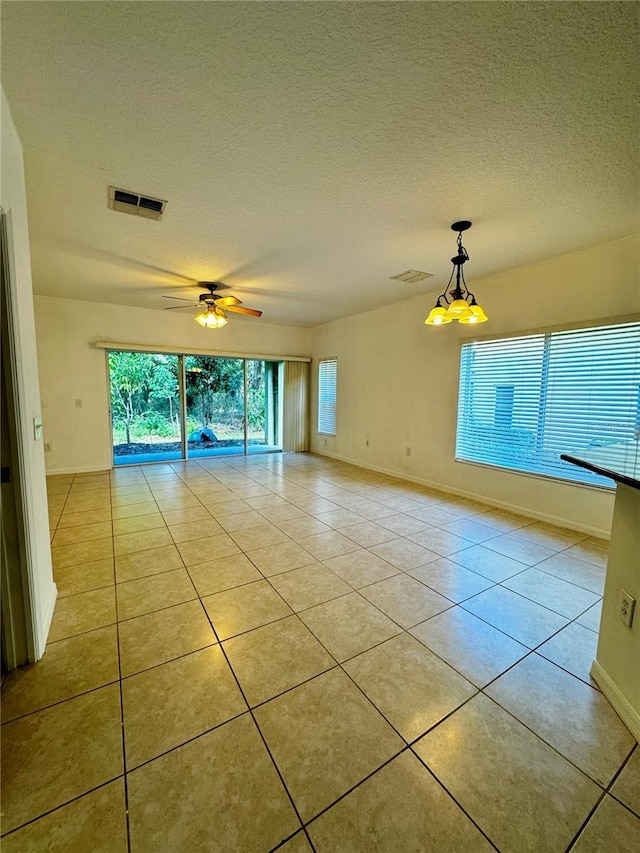 8550 Trail Wind Dr, Tampa, FL 33647 - spare room with light tile patterned floors, a textured ceiling, baseboards, and a ceiling fan