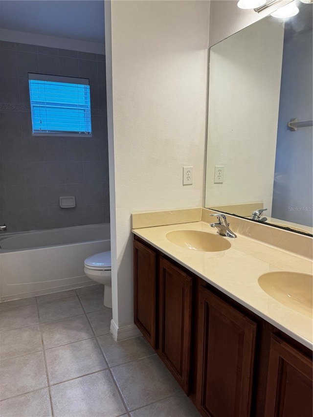 bathroom with double vanity, tile patterned flooring, a sink, and toilet