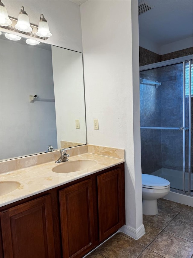 bathroom with toilet, double vanity, a sink, and visible vents