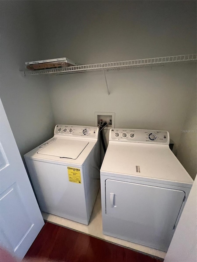 laundry area with separate washer and dryer and wood-type flooring