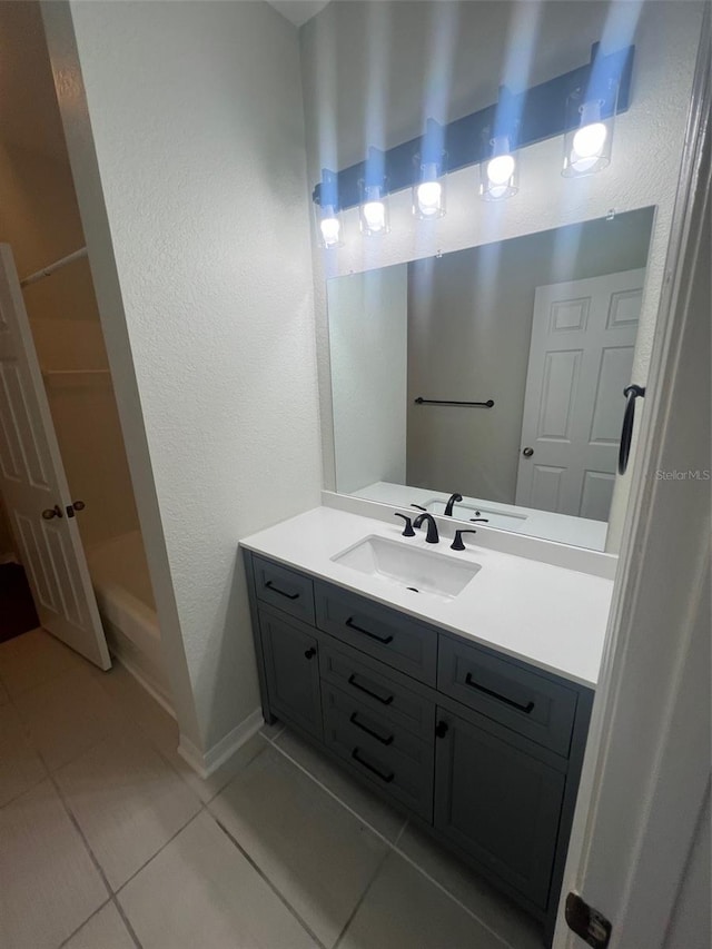 bathroom with a shower, vanity, and tile patterned flooring