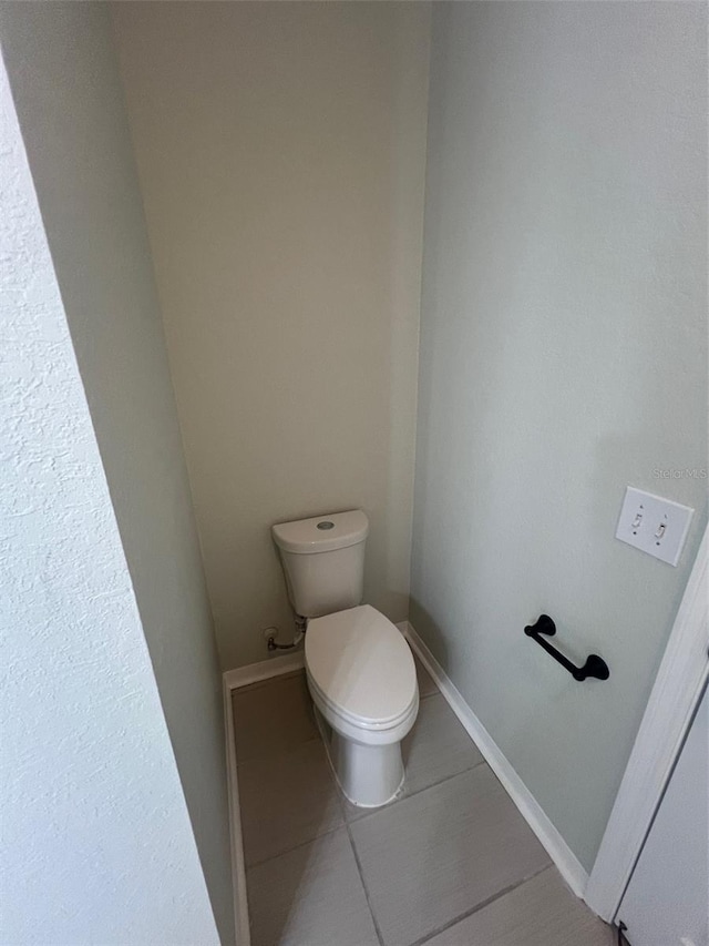 bathroom with toilet and tile patterned floors