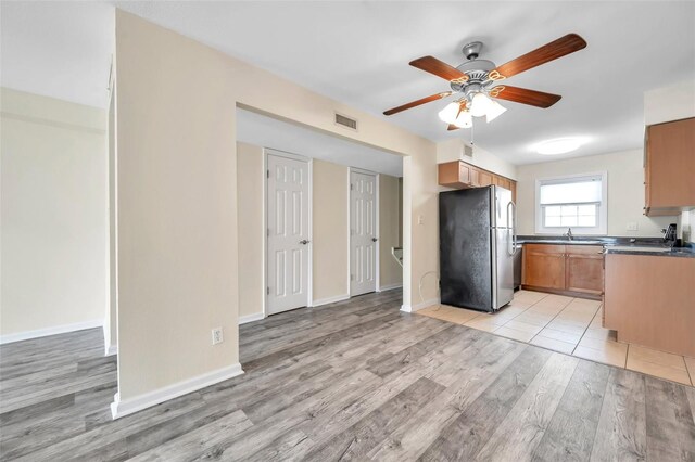 kitchen with light hardwood / wood-style floors, stainless steel fridge, sink, and ceiling fan