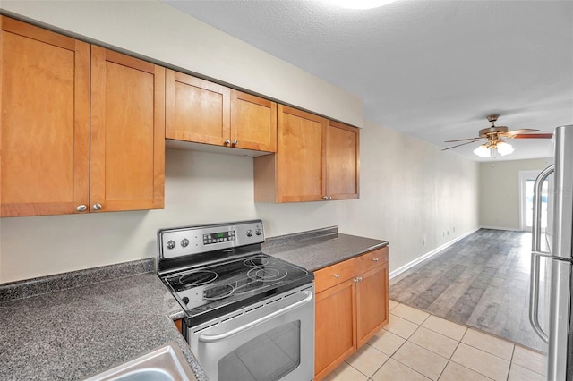 kitchen with light hardwood / wood-style flooring, a textured ceiling, stainless steel appliances, and ceiling fan