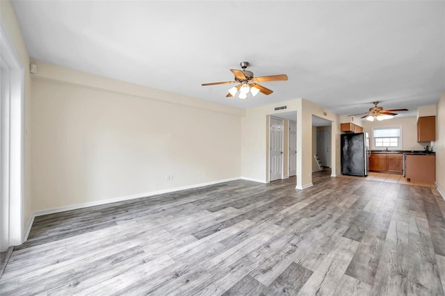 unfurnished living room featuring light hardwood / wood-style flooring and ceiling fan