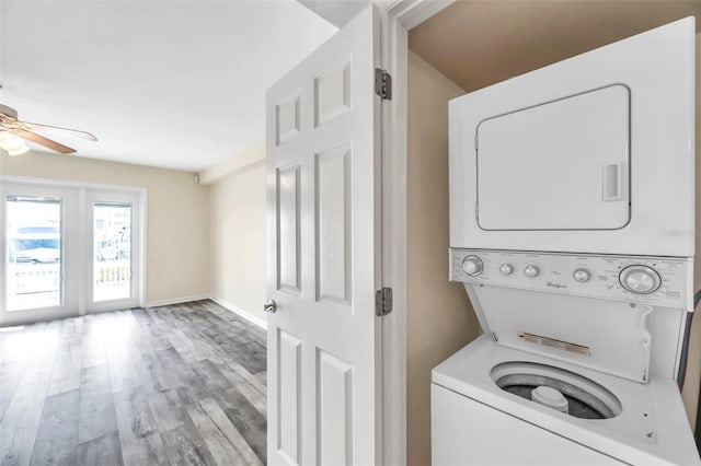 washroom featuring stacked washer / dryer, light wood-type flooring, and ceiling fan