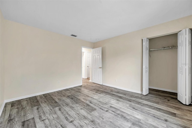 unfurnished bedroom featuring a closet and light wood-type flooring