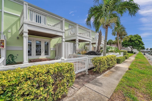 rear view of house featuring a balcony and french doors