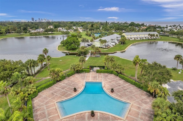 view of pool with a water view, a patio area, and a yard