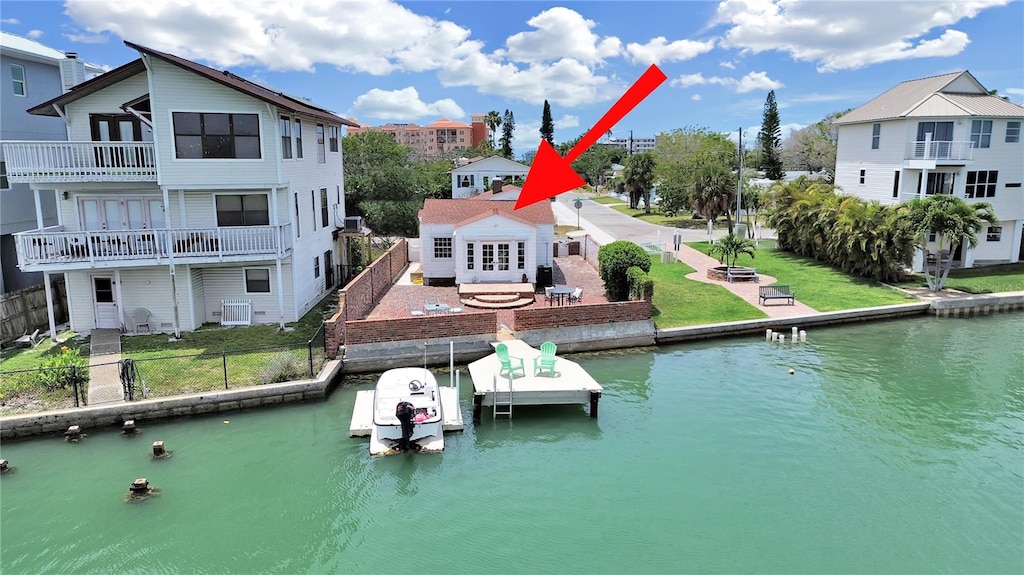 dock area featuring a lawn, a water view, and a balcony