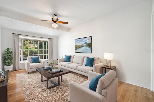 living room featuring ceiling fan, light hardwood / wood-style floors, and vaulted ceiling