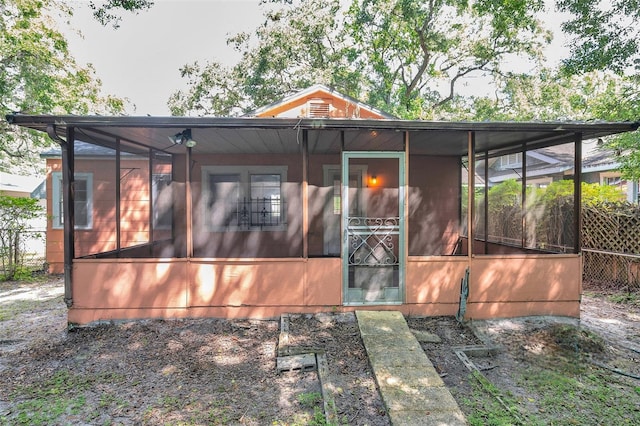 rear view of house featuring a sunroom