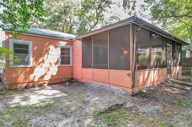 view of property exterior with a sunroom