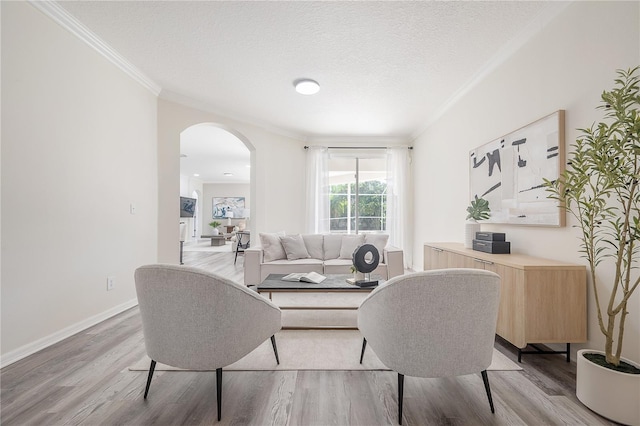 living room with crown molding, a textured ceiling, and hardwood / wood-style flooring