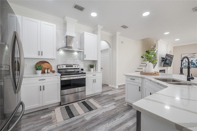 kitchen featuring appliances with stainless steel finishes, white cabinets, sink, and light hardwood / wood-style floors