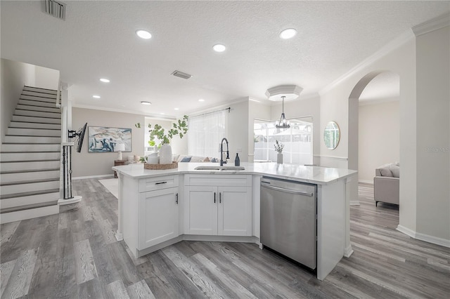 kitchen featuring white cabinets, a center island with sink, stainless steel dishwasher, light hardwood / wood-style flooring, and sink